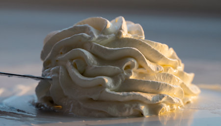 Close up of meringue on a white plate with a spoonの素材