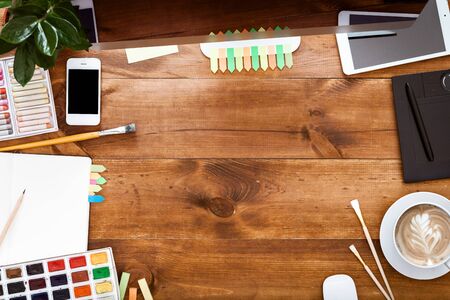 Modern creative design workplace concept, computer monitor and paints crayons devices on brown...