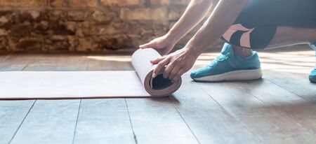 Closeup hands sporty woman rolling unrolling mat.