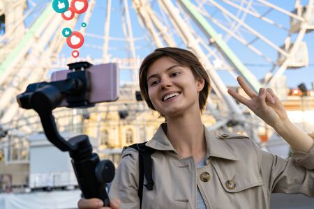 Girl blogger record travel vlog hold phone on selfie stick get likes.の写真素材