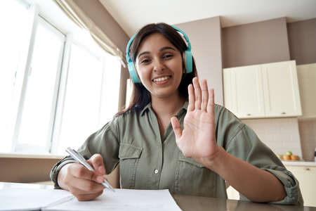 Happy indian online teacher looking at webcam video call remote teaching.の写真素材