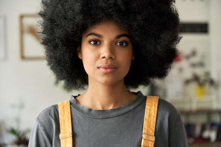 Confident African woman with Afro hair looks at camera, headshot portrait.の写真素材