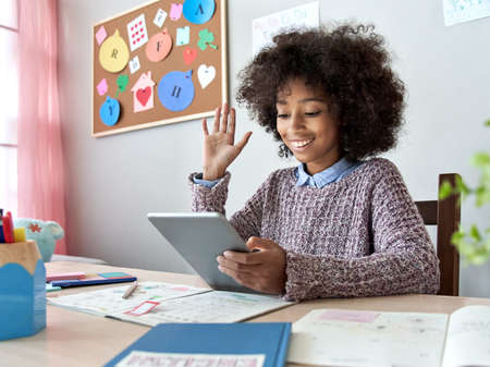 African kid girl waving hand video call remote learning on digital tablet.