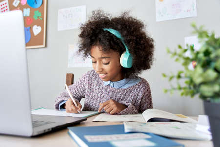 African school kid girl wearing headphones virtual distance learning at home.の写真素材