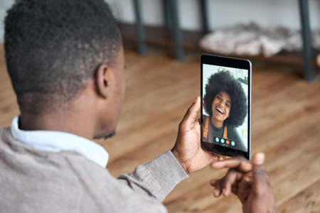African american man video calling girlfriend on digital tablet.