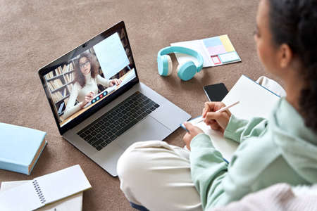 Teenage girl distance learning online video call class with remote teacher.の写真素材