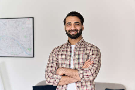 Portrait of young happy indian man looking at camera at home office.の写真素材