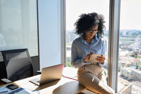 African American businesswoman at office using tablet pc at panoramic window.の写真素材