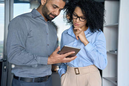 Multiracial employees colleagues working using tablet device in office.の写真素材