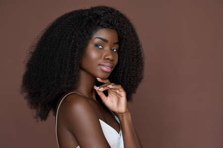 Smiling black young woman isolated on brown background. Beauty, skincare conceptの写真素材