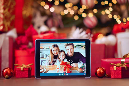 Family video call on digital tablet screen on Christmas table background.