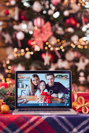 Family video call on laptop computer screen on Christmas table background.の写真素材