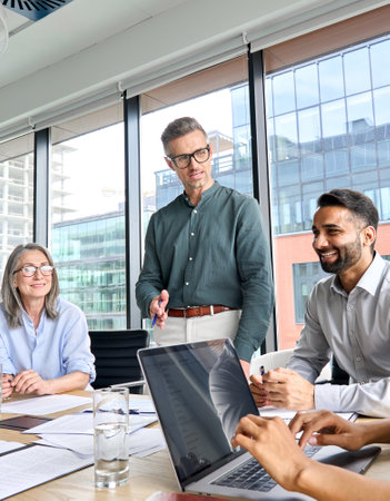 Ceo male leader talking to partners at meeting in boardroom in modern office.