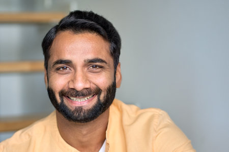 Happy smiling indian man looking at camera at home indoors. Close up portrait.の写真素材