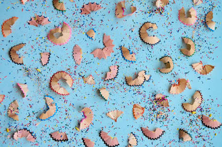 Many color pencils multicolored peels pattern on white background, flatlay.