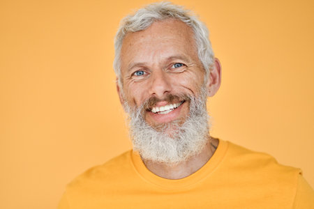 Smiling old senior man isolated on yellow background, headshot portrait.