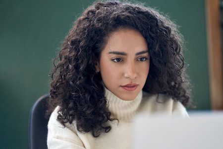 Young business woman looking at laptop watching online webinar at work.の写真素材