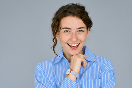 Happy young confident professional business woman at grey background, portrait.の写真素材