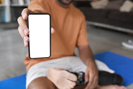 Amputee man with prosthetic leg disability showing mobile phone big screen.の写真素材