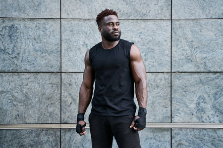 Strong confident sporty young black man boxer fighter standing outdoors.