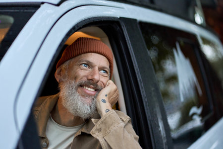Excited happy older man driving rv camper van looking outside enjoying view.