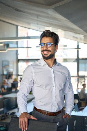 Confident Latin young business man wearing eyeglasses looking away.