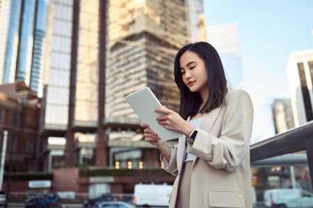 Young Asian business woman professional standing in city using digital tablet.の写真素材