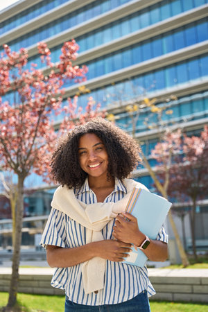 Smiling African girl student in university outdoor campus, vertical portrait.の写真素材