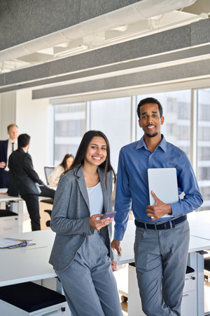 Smiling diverse colleagues standing in office meeting room, vertical portrait.