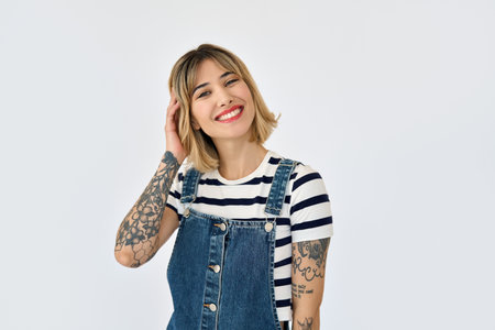 Happy gen z blonde young woman with tattoos standing isolated on white. Portraitの写真素材