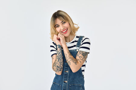 Happy gen z blonde stylish girl with tattoo standing isolated on white. Portraitの写真素材