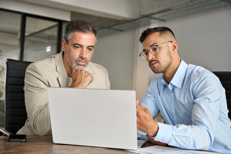 Busy business team people of two executive men working in office on laptop.の写真素材