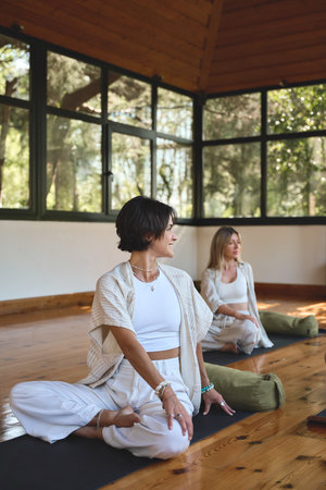 Young happy women group doing yoga exercises at yoga class in studio. Verticalの写真素材