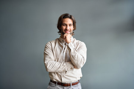 Portrait of happy young business man looking at camera isolated on gray wall.の写真素材