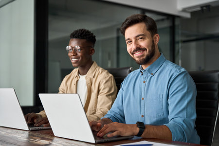 Professional young happy businessman working with colleague in office, portrait.