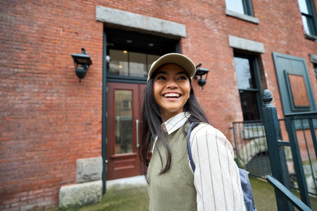 Happy Asian girl, cute teenage college student with backpack walking outdoors.の写真素材