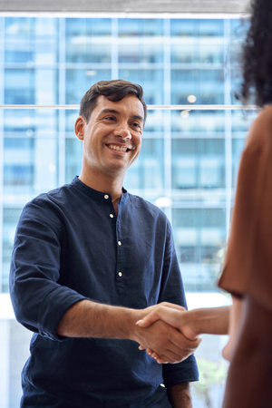 Handshake of happy business man and business woman meeting in office.の写真素材