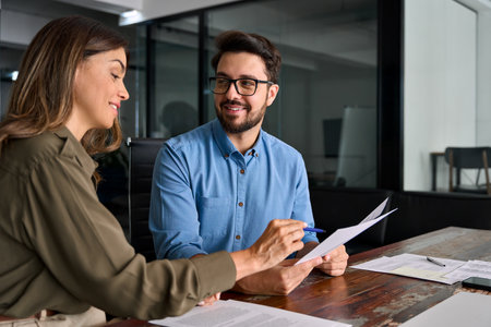 Smiling financial advisor attorney consulting client investor reading document.