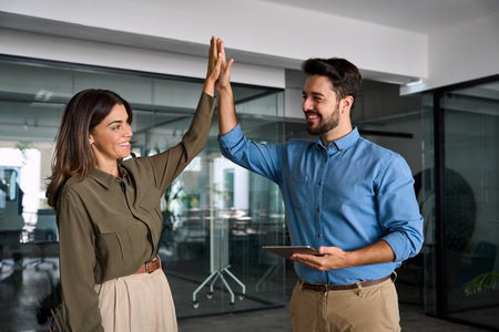 Happy business team of two people man and woman giving high five.