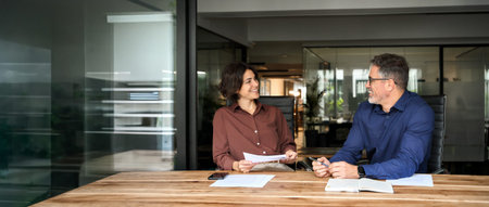 Happy professional executives team discussing papers working in office.