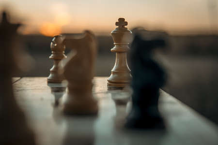 Chess game on the chessboard with selective focus on the king under a sunsetの写真素材