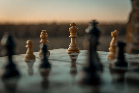 Chess game on the chessboard with selective focus on the king under a sunsetの写真素材