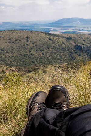Perspective of a hiker relaxing in the grass after hiking over some hillsの写真素材