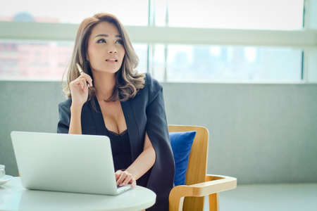 Young businesswoman sitting at office And holding penの写真素材