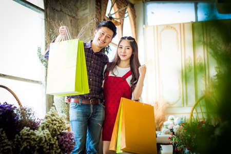 happy beautiful young man and woman in casual clothing with shopping bags.の写真素材