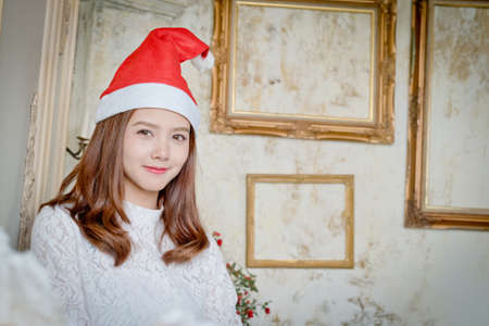 Beautiful girl in Christmas hat On a bright day.の写真素材