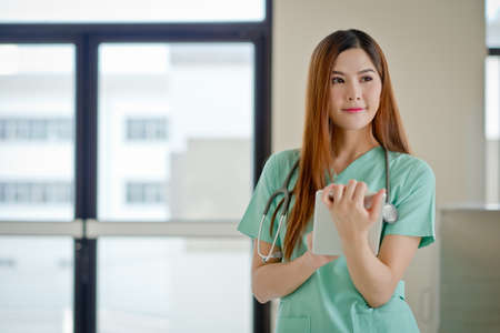 Young doctor woman smile face with stethoscope looking tablet computer.の写真素材