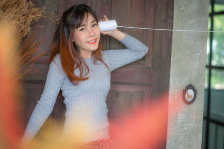 Cute girl talking through a tin phone.の写真素材