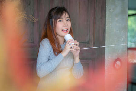 Cute girl talking through a tin phone.の写真素材