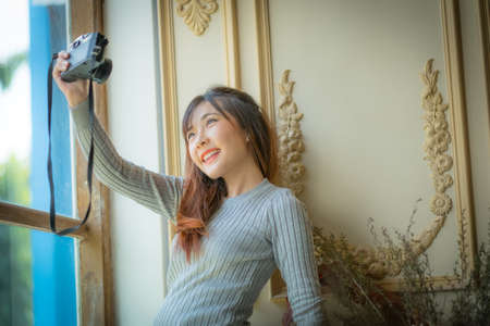 portrait of a beautiful hipster girl with a camera taking photos And shot himself.